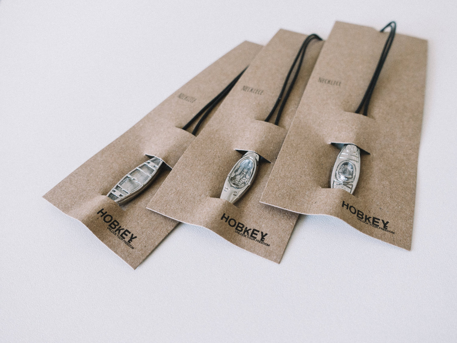 intricately designed highly polished stainless steel necklaces and keyrings: whitewater kayaks,  touring sea kayaking,  open canoeing